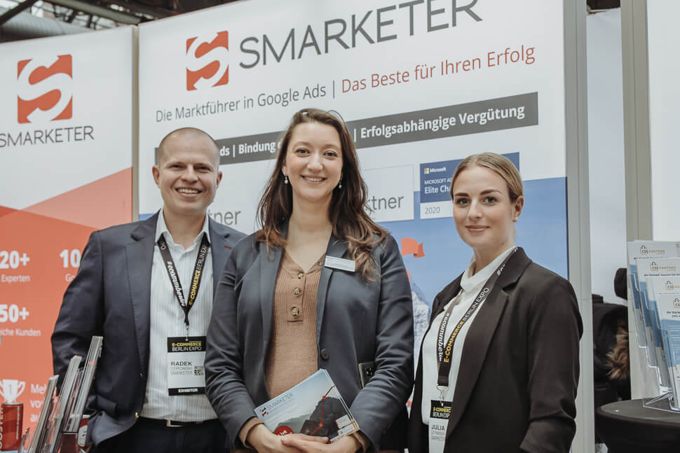 Das Messeteam von Smarketer, ein Mann, zwei Frauen, vor dem Smarketer Messestand auf der Ecommerce EXPO 2020 in Berlin