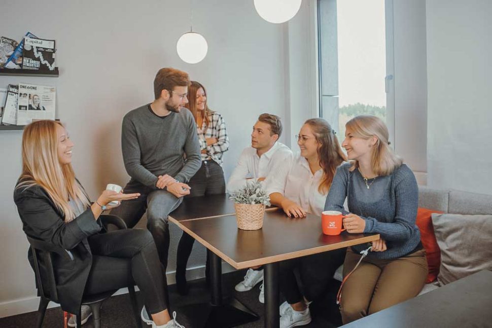 Gruppe von Mitarbeitern bei Smarketer sitzt am Tisch